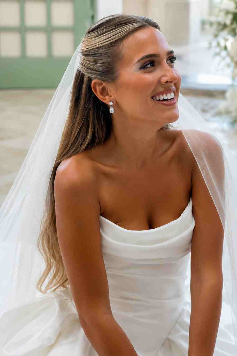 Bruid met nette sleek half opgestoken haar met sluier.