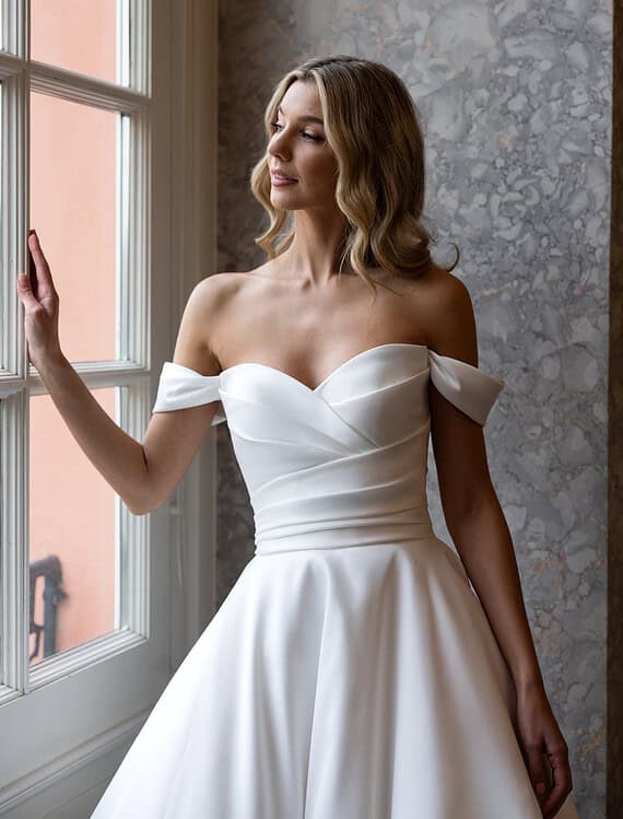 Honeymoonshop, winkel, trouwjurken, trouwpakken - Elegante trouwjurk met off-shoulder details.