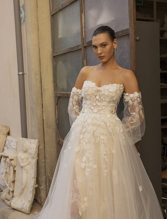 Elegante trouwjurk met kanten details en off-shoulder ontwerp.