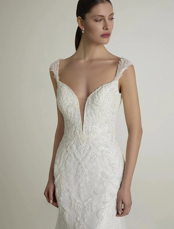 Elegante witte trouwjurk met kanten details en diepe V-hals voor bruiloft.