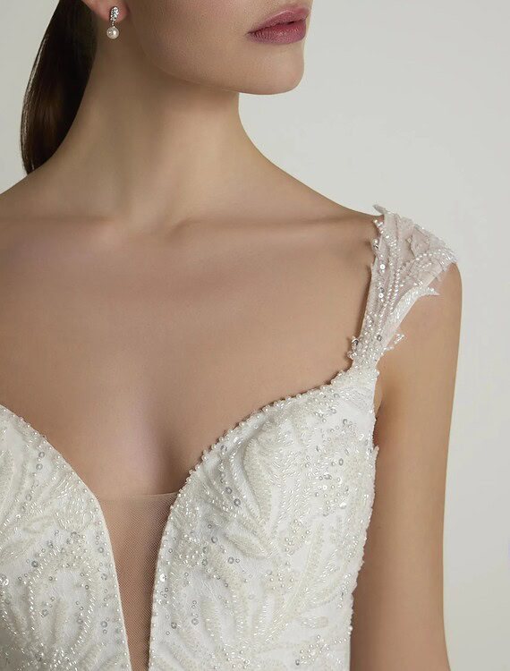 Elegante trouwjurk met parelversiering en delicate details voor de bruid.